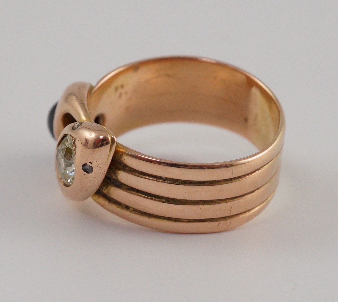 A gold, cabochon sapphire and yellow diamond set twin serpent head ring